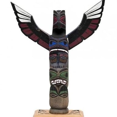 A carved pole with figures and emblems in a Northwest Coast Indigenous artistic tradition.