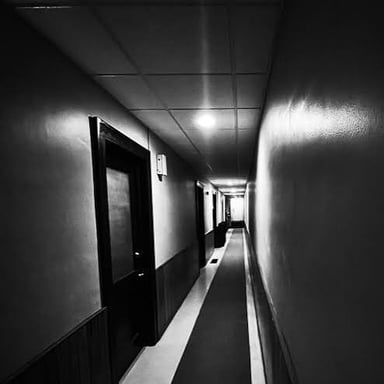 An empty, shadowy hallway has an unsettling atmosphere.