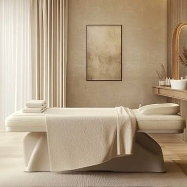 A calm spa treatment room with a massage table and folded towels.
