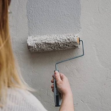 A paint roller applies a fresh layer of paint to a wall.