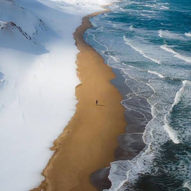 A sandy shoreline meeting the edge of the sea.