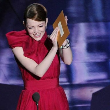 An award presenter holding an envelope before announcing a winner.