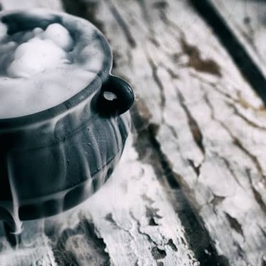 Mist spills over the rim of a cauldron as dry ice creates a fog effect.