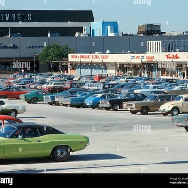 Cars parked in a lot outside a shopping mall.