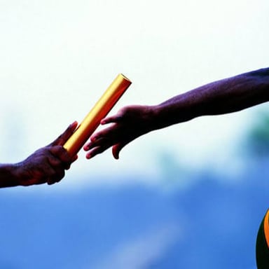 Runners passing a baton during a relay race