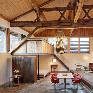 An attic room beneath a sloping roof, with rafters overhead.