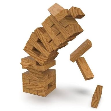 A wooden block tower falling during a game of Jenga.