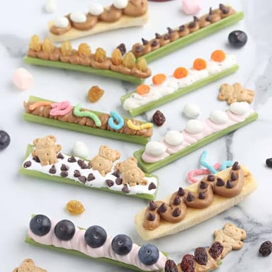 Celery sticks with peanut butter and raisins arranged as ants on a log