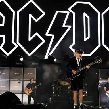 AC/DC performing onstage as a hard-rock band.