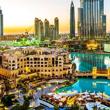 Dubai’s modern skyline beside a large shopping mall.