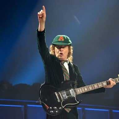 Angus Young performing with AC/DC while playing guitar