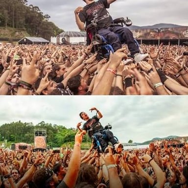 A crowd surfer being carried above a concert audience.
