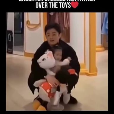 A parent comforting a baby after the baby drops a toy.