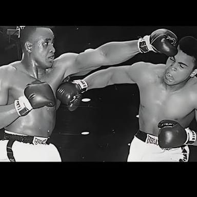 A boxer moving toward an opponent in a boxing ring.