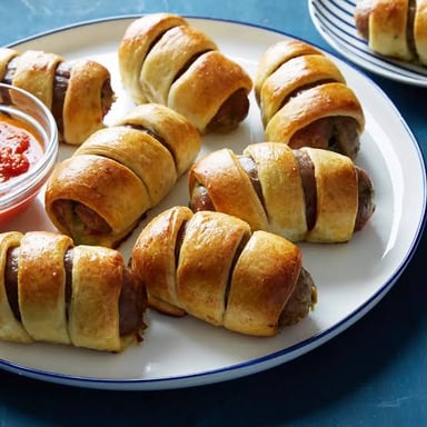 Small sausages wrapped in pastry, a common appetizer called pigs in a blanket.