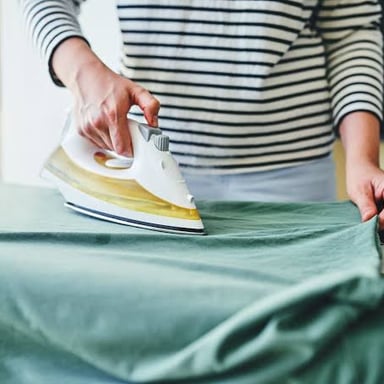 An iron smoothing wrinkles from a piece of clothing