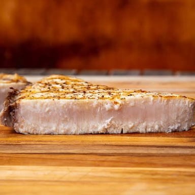 A cooked swordfish steak, showing the thick crosswise cut.