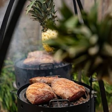 Meat cooking over embers on a parrilla during an Argentine asado.