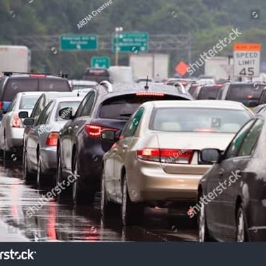 Cars wait closely together in slow-moving traffic.