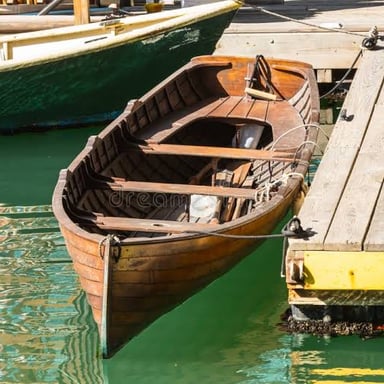 A boat secured beside a harbor dock with a mooring line.