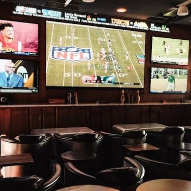 Several televisions showing sports in a bar.