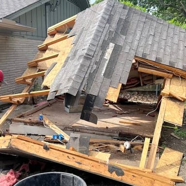 Workers dismantling a small wooden structure.