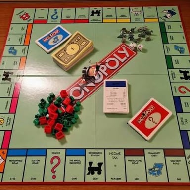 Two numbered dice beside a Monopoly game board.