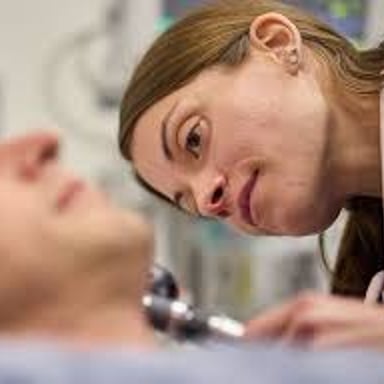 A physician in an ear, nose, and throat clinic examining a patient.