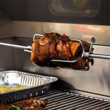 Meat is held on a long rotating spit above a heat source.