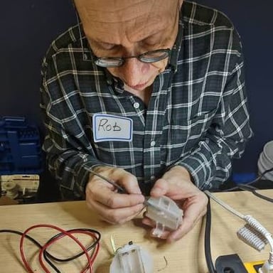 A person repairing an object with hand tools.