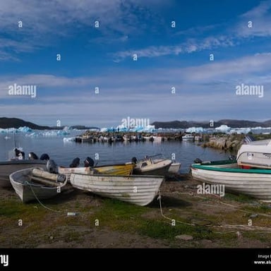 Boats resting in calm water inside a sheltered harbor.