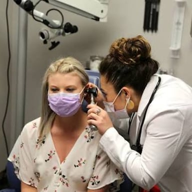 A patient meeting with a doctor in a clinic exam room.