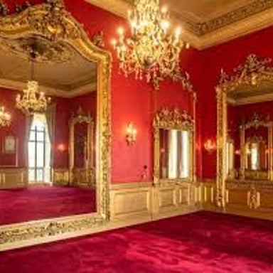An ornate ballroom with elaborate decoration and a chandelier.