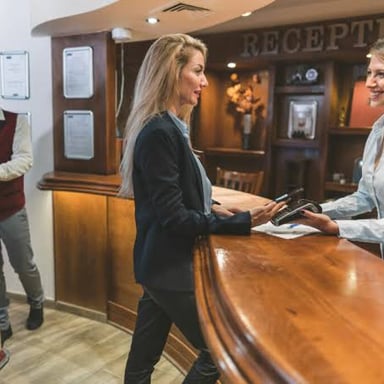 A hotel guest at a reception desk.