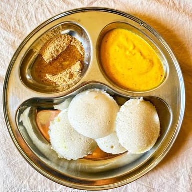 Soft steamed idlis served with South Indian sambar and chutney.