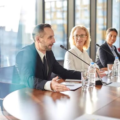A company executive leading a meeting around a conference table.
