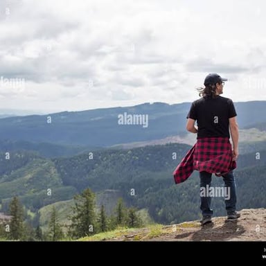 A person stands near the edge of a ridge.