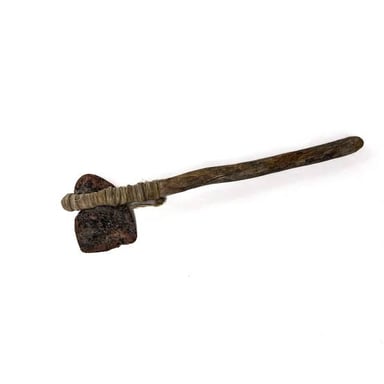 A reconstructed prehistoric axe with a shaped stone head hafted to a wooden handle