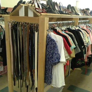 Secondhand clothing displayed on racks in a thrift store.