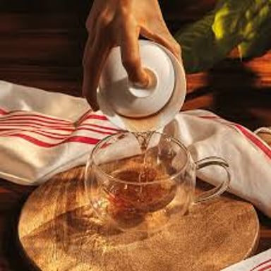 A cup of tea with hot water steeping the leaves.