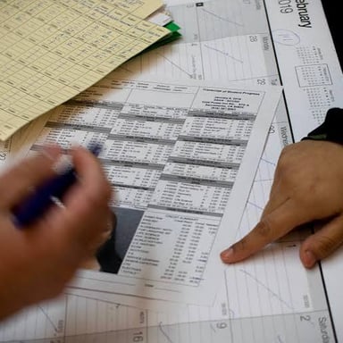 A student looks at an exam marked with an A beside a college transcript.