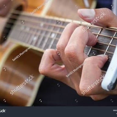 A musician plucks a guitar string, producing a twang.