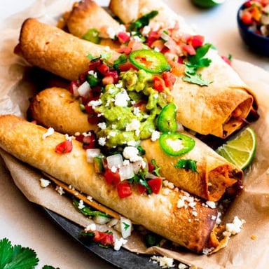 Crisp rolled Mexican flautas served with salsa and toppings.