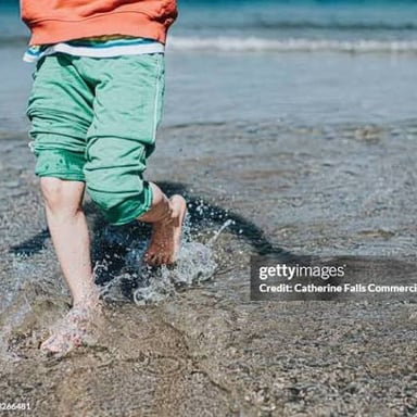 Person moving through shallow water with splashes.