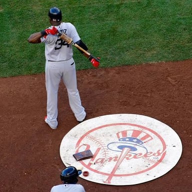 A baseball player waiting in the on-deck circle before taking a turn at bat.