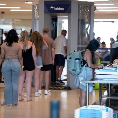 Carry-on luggage moves through an airport security screening checkpoint.
