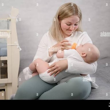 A newborn baby held gently in a caregiver's arms.