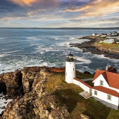 A rocky Maine coastline beside a small harbor town.