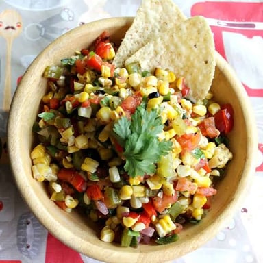 Corn salsa served in a bowl, with visible corn kernels and diced vegetables.