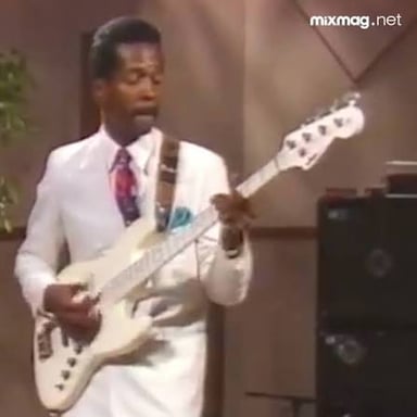 A musician uses a percussive slap technique on an electric bass.